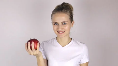 Beautiful girl bites a big and juicy red apple Stock Footage 88289953