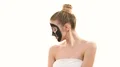 The beautiful girl with a black face care mask gesturing on the white background 4k or 4k+ Resolution