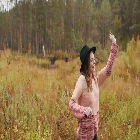 Beautiful girl in a black hat dancing in the autumn forest Stock Footage 69703792
