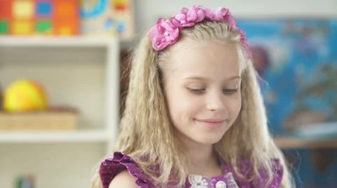 Beautiful girl with blond hair smiling and drawing with colored pencil Stock Footage