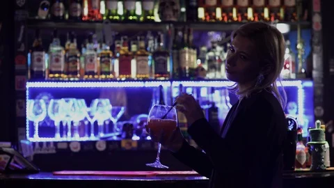Blond lady drinking cocktail standing ne... | Stock Video | Pond5