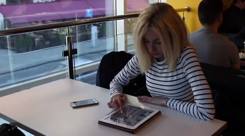 Beautiful girl in the cafe is using tablet PC  Stockbeeldmateriaal 63166393