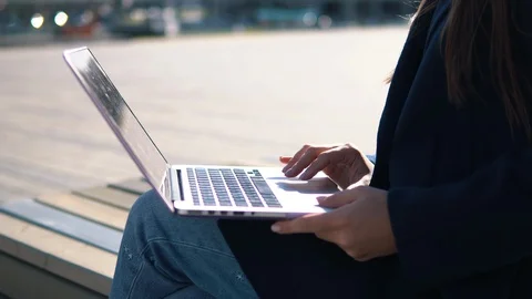 Beautiful girl in coat is making notes and smiling while working with a laptop Stock Footage 95877784