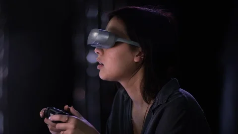 Beautiful girl with controller playing a game in virtual reality VR Stock Footage 101254681
