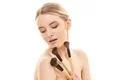 The beautiful girl with cosmetic brushes on the white background Photo