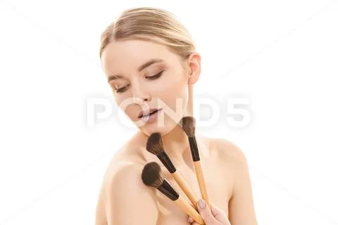 The beautiful girl with cosmetic brushes on the white background Stock Photos