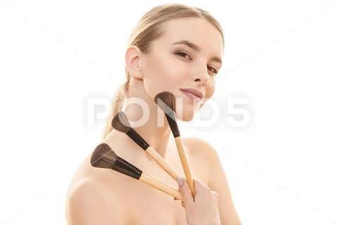The beautiful girl with cosmetic brushes on the white background Stock Photos
