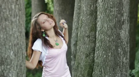 Beautiful girl dances between trees Stock Footage