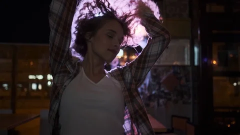 Beautiful girl dancing alone in the rays of spotlights at a party in a nightclub Stock Footage 107002310