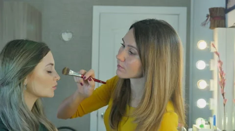 Beautiful girl doing makeup Stock Footage