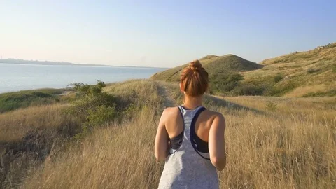 Beautiful girl doing morning jogging at sunrise in the field. outdoors fitness Video stock 79143353