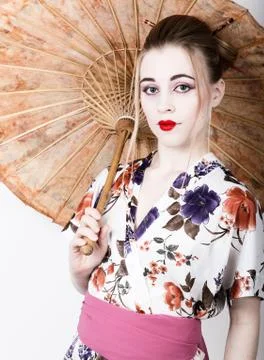 Beautiful girl dressed as a geisha girl holding a Chinese umbrella. Geisha Stock Photos