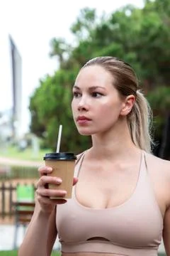 Beautiful girl drinking a drink from a cardboard glass in nature Stock Photos