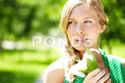 A beautiful girl with flower looking away Stock Photos