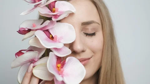 Beautiful girl with flower posing in front of camera Stock Footage 128975736
