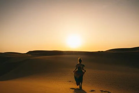 Beautiful girl in the golden dessert and sunset Stock Photos