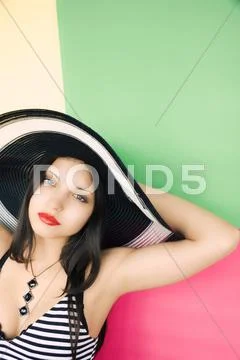 The beautiful girl in a hat on a colour background Stock Photos
