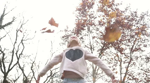 Beautiful girl having fun throwing leaves in the air Stock Footage 59553959