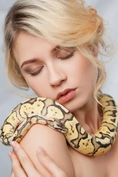 Beautiful girl  holding a python, which wraps around her body Foto stock