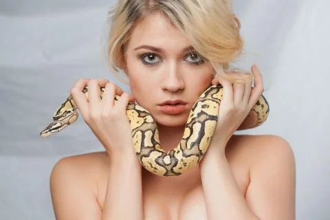 Beautiful girl  holding a python, which wraps around her face 写真素材
