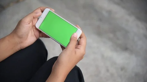 Beautiful girl holding a smartphone in the hands of a green screen green screen, Stock Footage