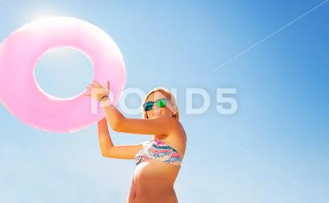 Beautiful girl holding swim ring against blue sky Stock Photos