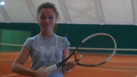 Beautiful girl holding a tennis racket and smiling on the court Stock Footage