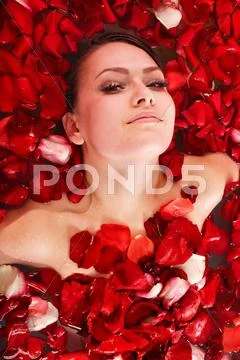 Beautiful girl in jacuzzi with rose petal. Stock Photos
