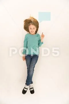 The beautiful girl lay on floor and show finger. View from above Stock Photos