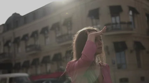 Beautiful girl is looking for someone on the streets of an old European city Stock Footage