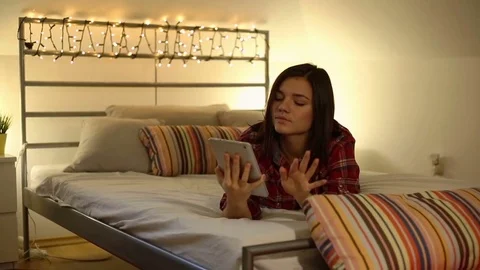 Beautiful girl lying on bed using touchpad Stock Footage 70128452