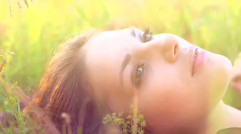 Beautiful Girl Lying on the Meadow and Dreaming Stock Footage
