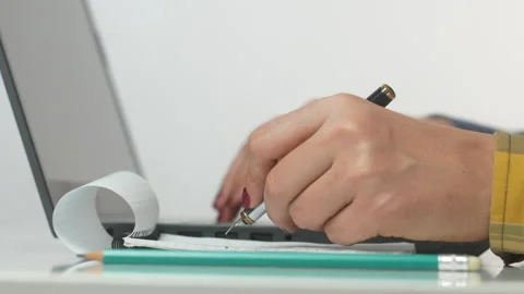 Beautiful girl makes a note in a notepad and laptop Stock Footage 270447979