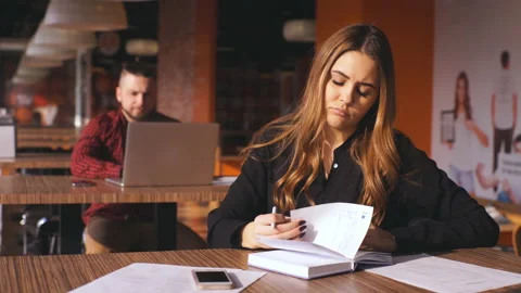 Beautiful girl is making notes in cafeteria Stock Footage 87189087
