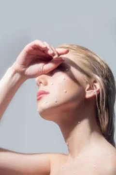 Beautiful girl with pearls on the skin of the face Stock Photos