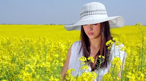 Beautiful girl posing and thinking in a yellow field Stock Footage 24664448