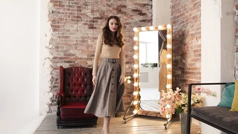Beautiful girl posing next to a mirror and a red chair.  動画素材 105008090