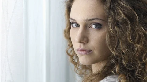 Beautiful girl posing next to a window Stock Footage 89650625