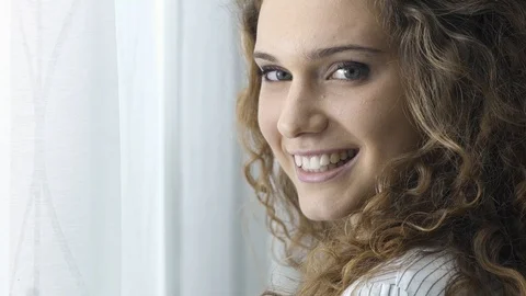 Beautiful girl posing next to a window Stock Footage 89650796
