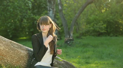 Beautiful girl posing at sunset at the tree in the forest. Stock Footage 64141548