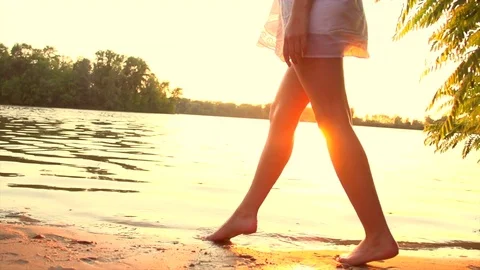 Beautiful girl in short white dress running on sunset beach Stock Footage