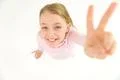 The beautiful girl show two fingers to the camera. View from above Photo
