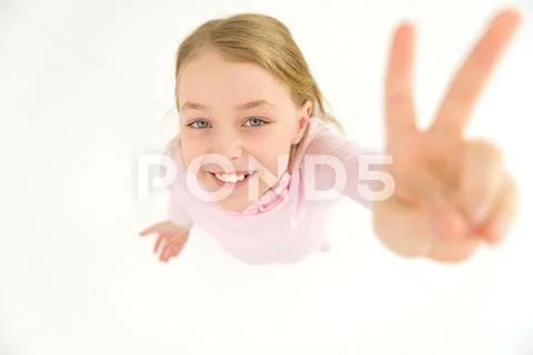 The beautiful girl show two fingers to the camera. View from above Stock Photos