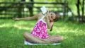 Beautiful girl sits on the grass and makes selfie on his smartphone HD Footage