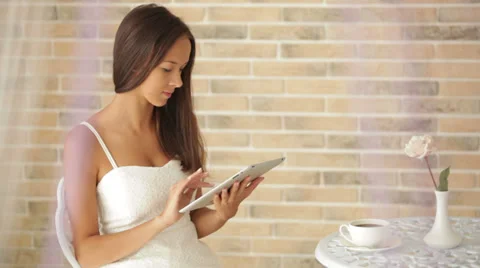 Beautiful girl sitting at cafe using touchpad looking at camera and smiling Stock Footage 34196604