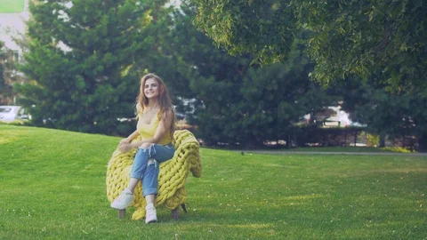 Beautiful girl sitting in the Park on a chair Vídeo Stock 93780098