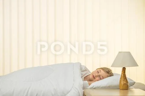 The beautiful girl sleeping on the bed Stock Photos