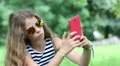Beautiful girl with sunglasses makes selfie on his smartphone HD Footage