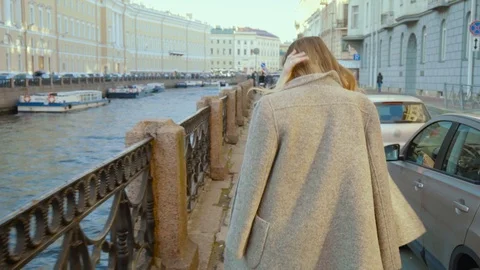 Beautiful girl takes off coat while walking city Stock Footage 87583658