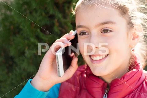 Beautiful girl talking on a smartphone in red vest Stock Photos